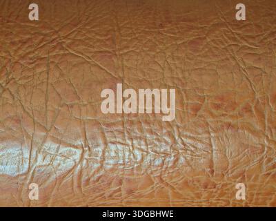 Brown artificial leather close up with crinkled, weathered texture and rich, rugged surface  seamless backdrop for design, upholstery, vintage or abst Stock Photo