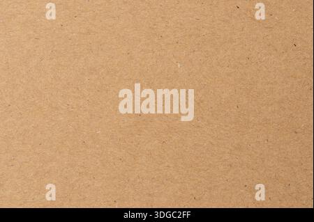 Plain brown paper on a flat surface used for various craft activities and packaging needs in a workspace at daytime. Stock Photo