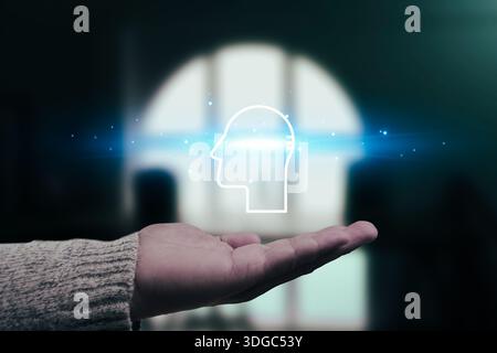 AI Human Intelligence Concept, Unlock the future of thought. A hand holds a glowing holographic icon of a human profile, representing Artificial Intel Stock Photo