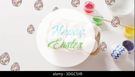 Image of happy easter text over eggs and paints on white background Stock Photo