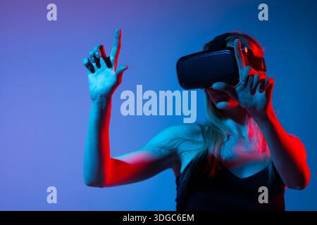 Virtual reality interaction with woman using hand gestures, immersive digital interface and metaverse technology experience Stock Photo