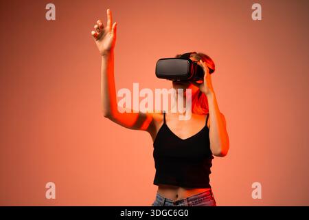 Woman engineer reaching into virtual reality space using VR headset, futuristic user experience, innovation, metaverse and immersive technology Stock Photo