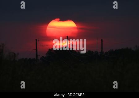 Red Sunset through Clouds and Power Lines, Central Minnesota Stock Photo