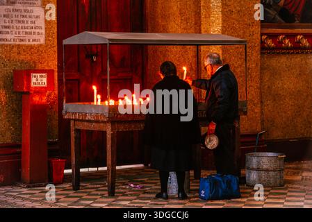 Couple lighting candles in church Stock Photo
