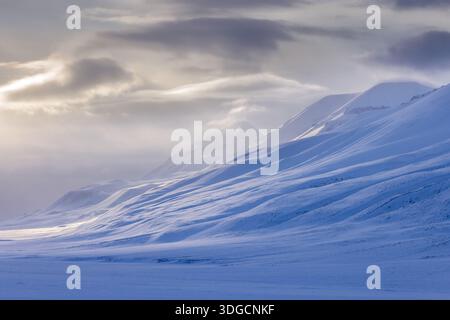 Snow covered mountain peaks along Adventdalen / Advent Valley near Longyearbyen at sunset in spring, Spitsbergen / Svalbard, Norway Stock Photo