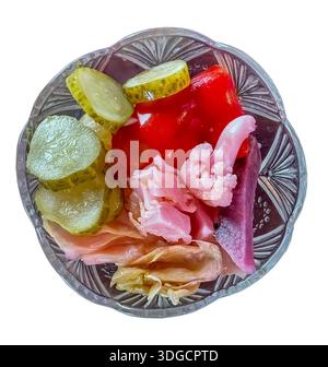 A glass bowl of salad with cucumbers, red pepper, cauliflower, cabbage, isolated. Top view. Stock Photo
