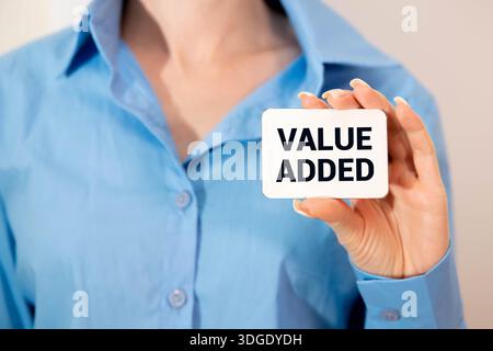 Yellow plastic forklift hold letter V to complete word value on wood background Stock Photo