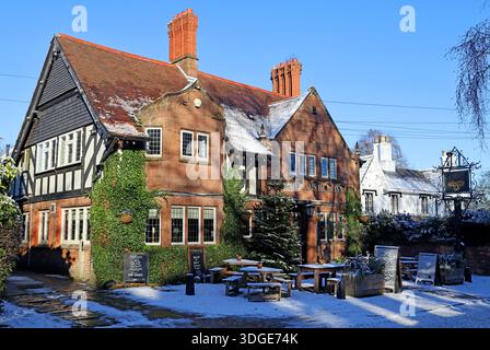 The Rams Head public house in the village of Grappenhall near Warrington,Cheshire, photographed in winter with snow on the ground and a Christmas tree Stock Photo