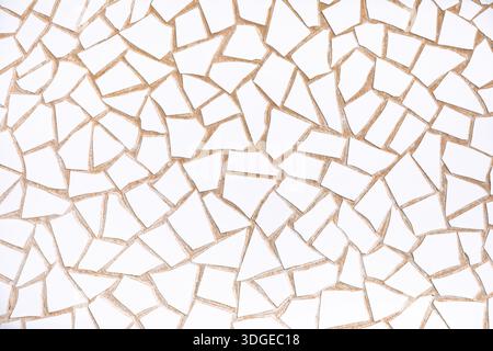 Irregular white mosaic tiles forms textured, abstract pattern background, blending edges with grout lines. Fragmented design evokes modern minimalism Stock Photo