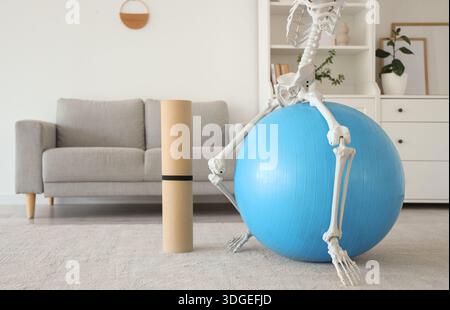 Human skeleton model on fitball in living room Stock Photo