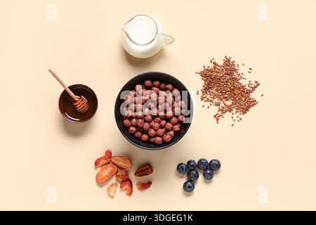 Bowl with cereal breakfast, milk and ingredients on beige background Stock Photo