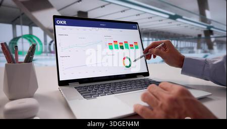 Mid-aged Caucasian Man Using Laptop To Track Market Trends In Office. Stock Photo