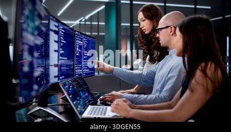 Team Of Engineers Collaborating On Software Development In Busy Office Stock Photo