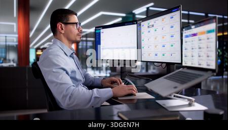 Hispanic Man Utilizes Cloud-based Management Software To Organize Business Documents. Stock Photo