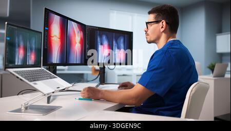 Young Latino Surgeon Examining Knee X-ray Using Advanced Software Technology. Stock Photo
