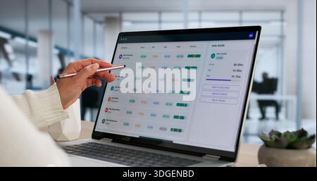 Female Business Analyst Using Employee Timetable Software On Laptop Stock Photo