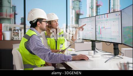 Engineers Using Industrial Energy Monitoring System For Oil Refinery Data Analysis Stock Photo