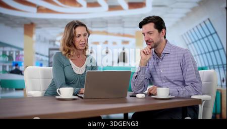 Business Partners Collaborating On Projects In Airline Lounge At Airport. Stock Photo