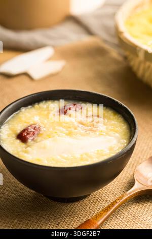 Nutritious multi grain porridge with red dates and yam served in a black bowl for health and wellness Stock Photo