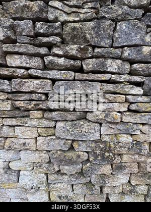 Close-up of traditional dry stone wall made from weathered limestone blocks, forming a natural rustic stone texture. Stock Photo