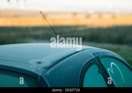 Frost and ice covering a car roof and window, showing a heart shape Stock Photo