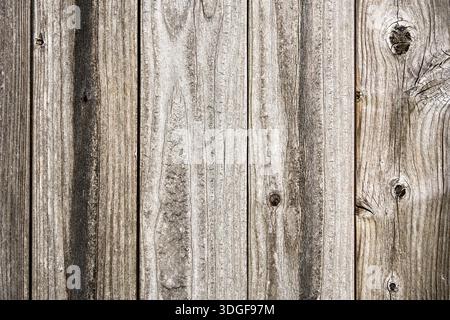 Close-up of weathered vertical wooden boards with visible grain, knots, and a natural aged gray-brown tone. Stock Photo