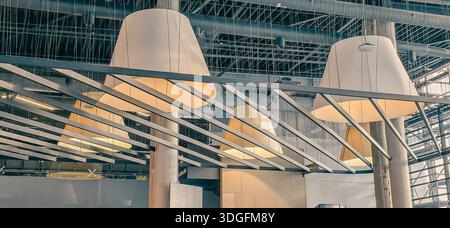 Large decorative lamps hanging from the ceiling in the interior. Minimalist elegance and style Stock Photo
