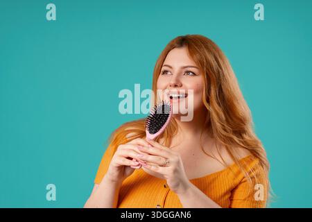 Body Positive Woman Singing, Dancing With Hair Brush Instead Microphone On Blue Stock Photo