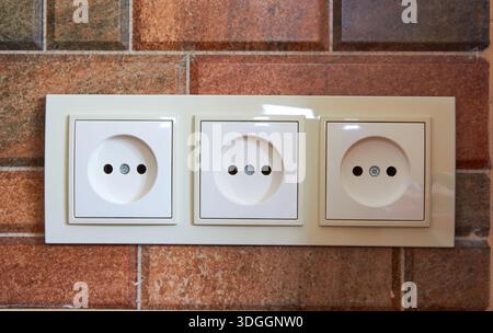 in the kitchen on a ceramic tile triple electrical outlet Stock Photo