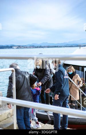 Santander, Spain – Nov 19, 2021: Passengers, some wearing face masks, disembark from the 'Regina Catorce' tour boat in the Bay of Santander with help Stock Photo