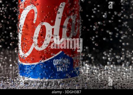A colorful can of cola immersed in carbonated water Stock Photo