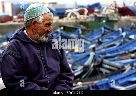 Shoreline Rake Fishing boats sit in the harbor under fog in Essaouira, Morocco, on ...