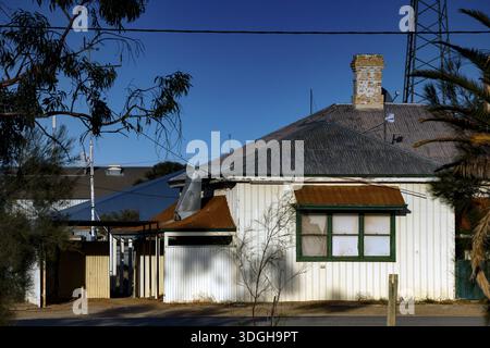 Single-family house in Marree with surrounding vegetation and blue sky, Marree, South Australia, Australia Stock Photo