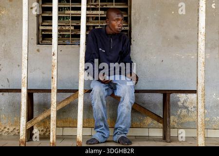 A man sits thoughtfully on a bench in a psychiatric facility in Bouake, Bouake, Saint Camille, Nimbo, Cote d'Ivoire Stock Photo