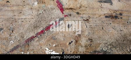 Rough concrete plastering over old wooden planks with red paint spots creating an abstract background Stock Photo