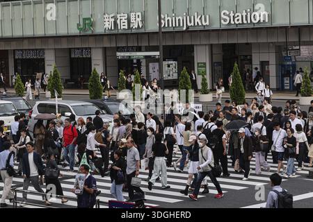 Passers-by cross the street in front of Shinjuku Station in Tokyo, Tokyo, Shinjuku, Japan Stock Photo
