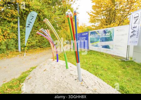 Colorful fiber optic cables sticking out of a pile of soil on a green area, fiberglass groundbreaking, Dornstetten, Freudenstadt, Germany Stock Photo