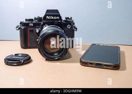Bristol UK 01-17-2026 A retro Nikon F3 camera with a Zoom-Nikkor lens and a smartphone are displayed suggesting a comparison between old and new tech Stock Photo
