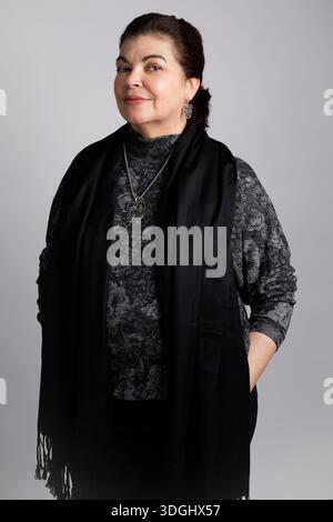 Portrait of adult Latin American woman in studio, gray background Stock Photo