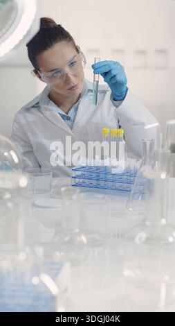 Female scientist working in a laboratory using a pipette and a test tube. Mixing and examining liquid samples for biotechnology, pharmaceutical, medic Stock Photo