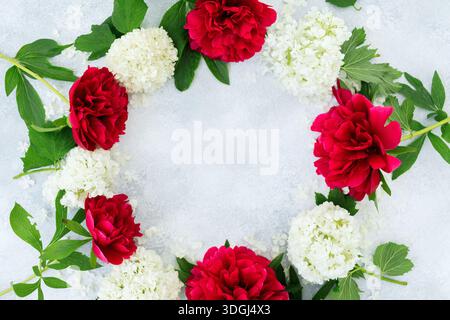 Floral wreath with red and white flowers on light background, round frame with copy space Stock Photo