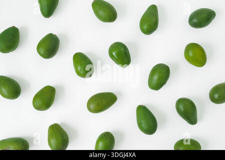 Fresh green avocados pattern on white background, healthy food concept, minimal flat lay composition. Stock Photo