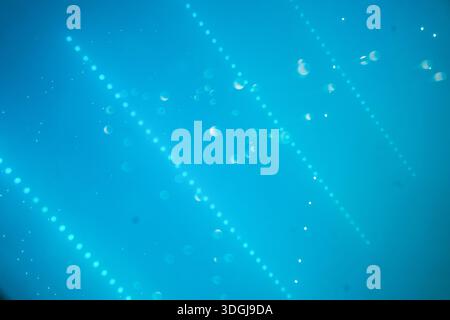 Abstract blue technology background featuring glowing particle dots, diagonal light beams, and bokeh effects. A futuristic digital network atmosphere Stock Photo