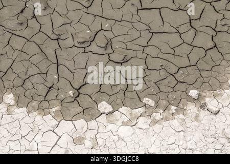An abstract background of dry, cracked earth. The parched mud creates a beautiful mosaic pattern from the intense heat and drought. A concept of clima Stock Photo