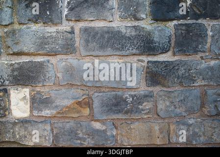 Clean, rectangular slate-colored stone blocks with visible mortar lines. A professional architectural texture for modern building facades. Stock Photo