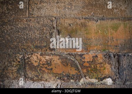 Large, weathered stone blocks with distinct mineral staining and rough-hewn surfaces. A versatile background for urban or historic structural design. Stock Photo