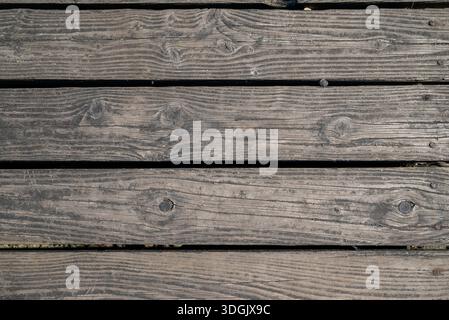 A high-resolution top-down shot of aged, rustic wooden planks with visible grain, knots, and cracks—perfect for background textures. Stock Photo