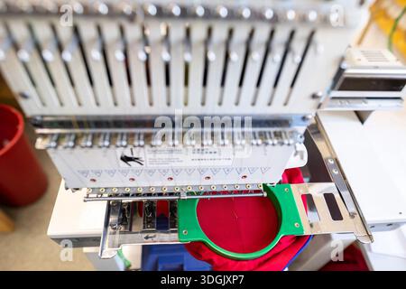 Close-up of the head of a professional multi-needle embroidery machine. Industrial equipment for automated sewing and textile manufacturing in a facto Stock Photo