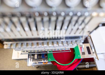 Close-up of the head of a professional multi-needle embroidery machine. Industrial equipment for automated sewing and textile manufacturing in a facto Stock Photo