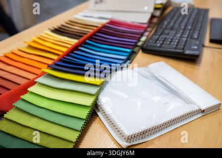 Colorful fabric swatch books on a designer's desk. A concept of choosing materials and color palettes for fashion, upholstery, or interior design. Stock Photo